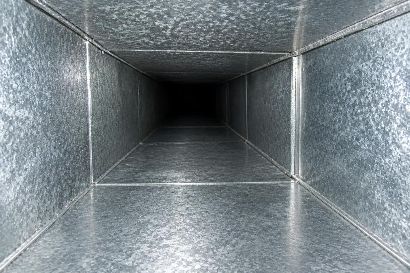 The same air duct after cleaning: bare, shiny metal